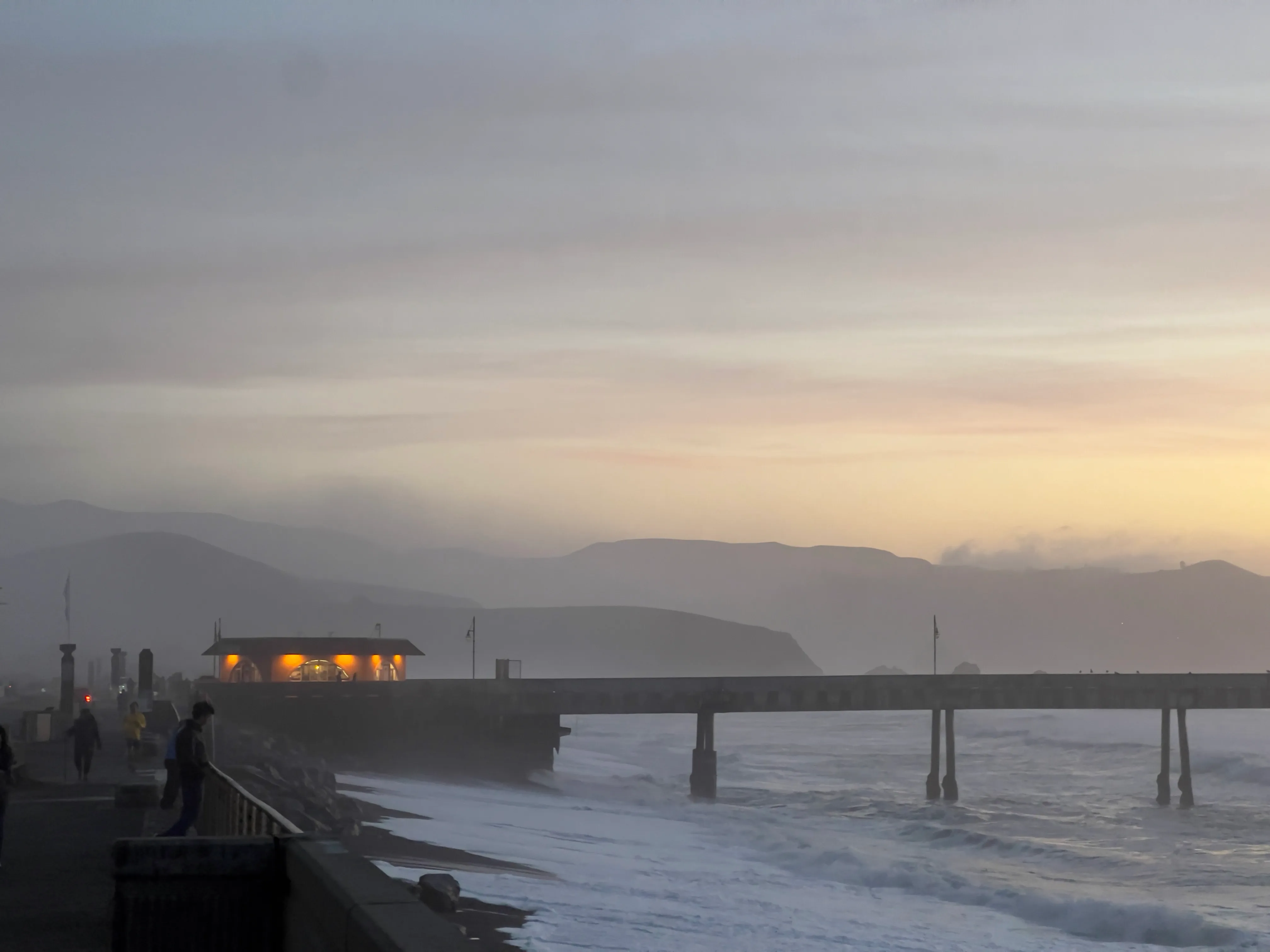 Pier and its reflection swallowed by dusk fog